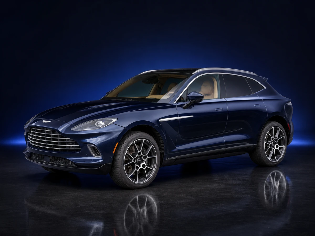 Blue Aston Martin DBX SUV on a deep navy and cobalt studio background.