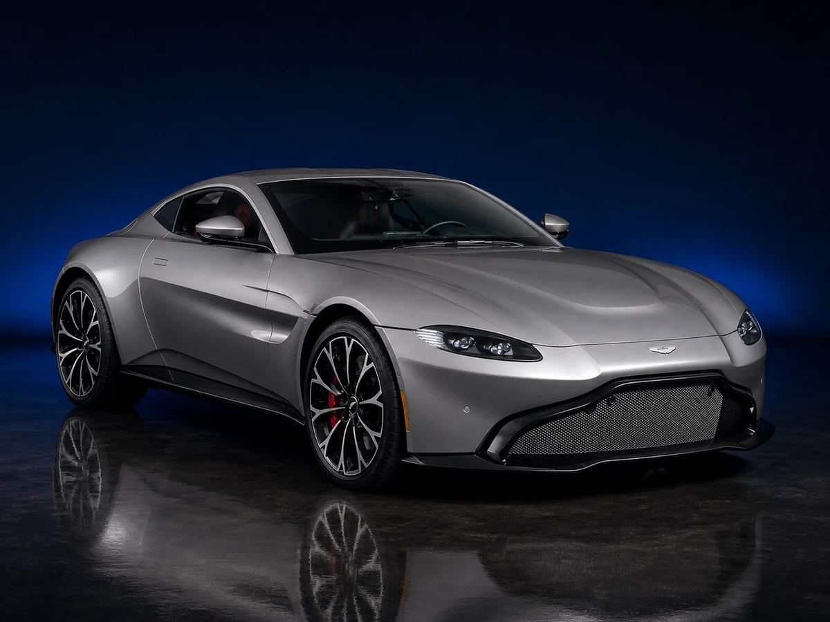 Grey Aston Martin Vantage 2019 coupé on a deep navy and cobalt studio background.