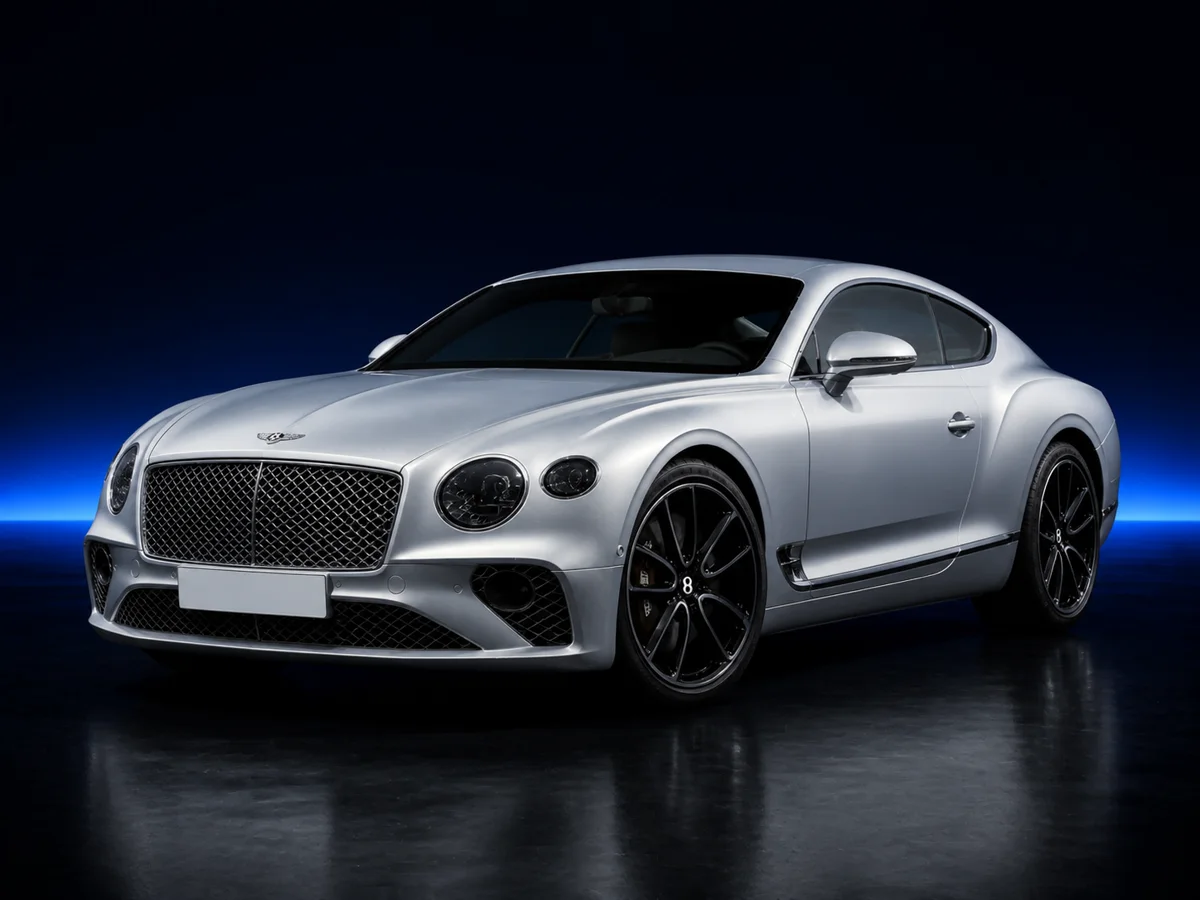 Silver Bentley Continental GT on a deep navy and cobalt studio background.