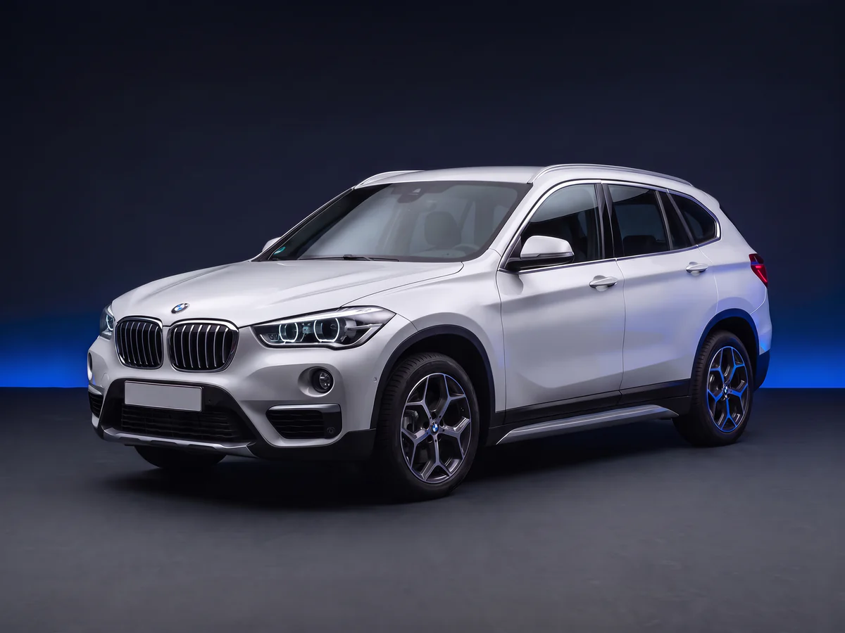 Silver BMW X1 F48 xDrive25d on a deep navy and cobalt studio background.