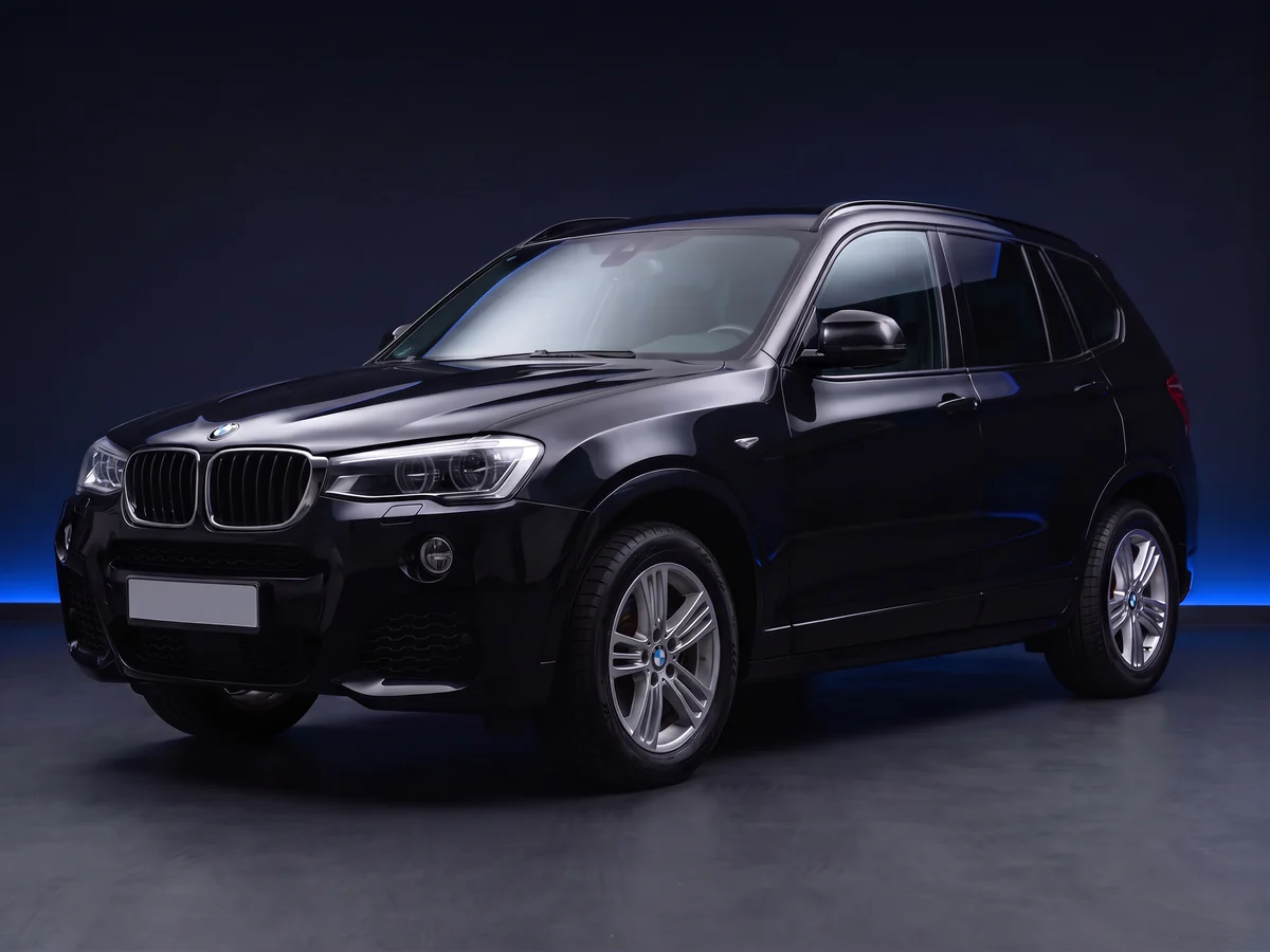 Black BMW X3 F25 facelift M Sport on a deep navy and cobalt studio background.
