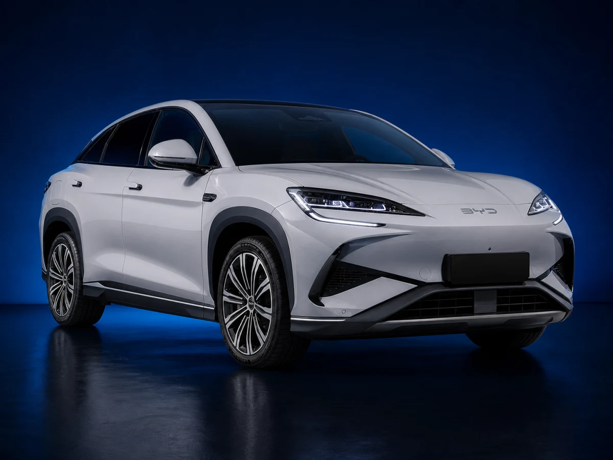 Shark-grey first-generation BYD Sealion 7 electric coupé SUV on a deep navy and cobalt studio background.