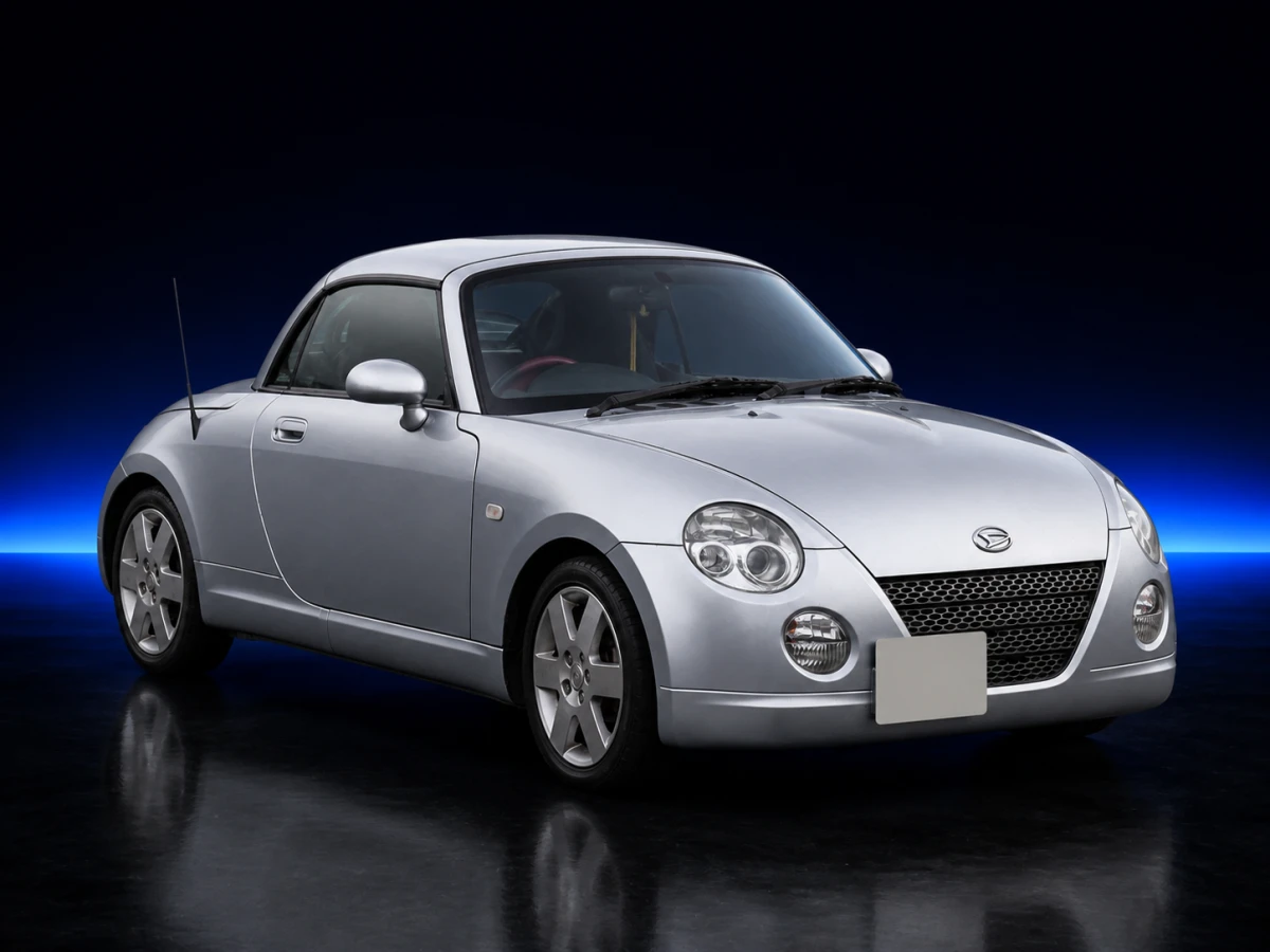 Silver Daihatsu Copen I L880 roadster on a deep navy and cobalt studio background.