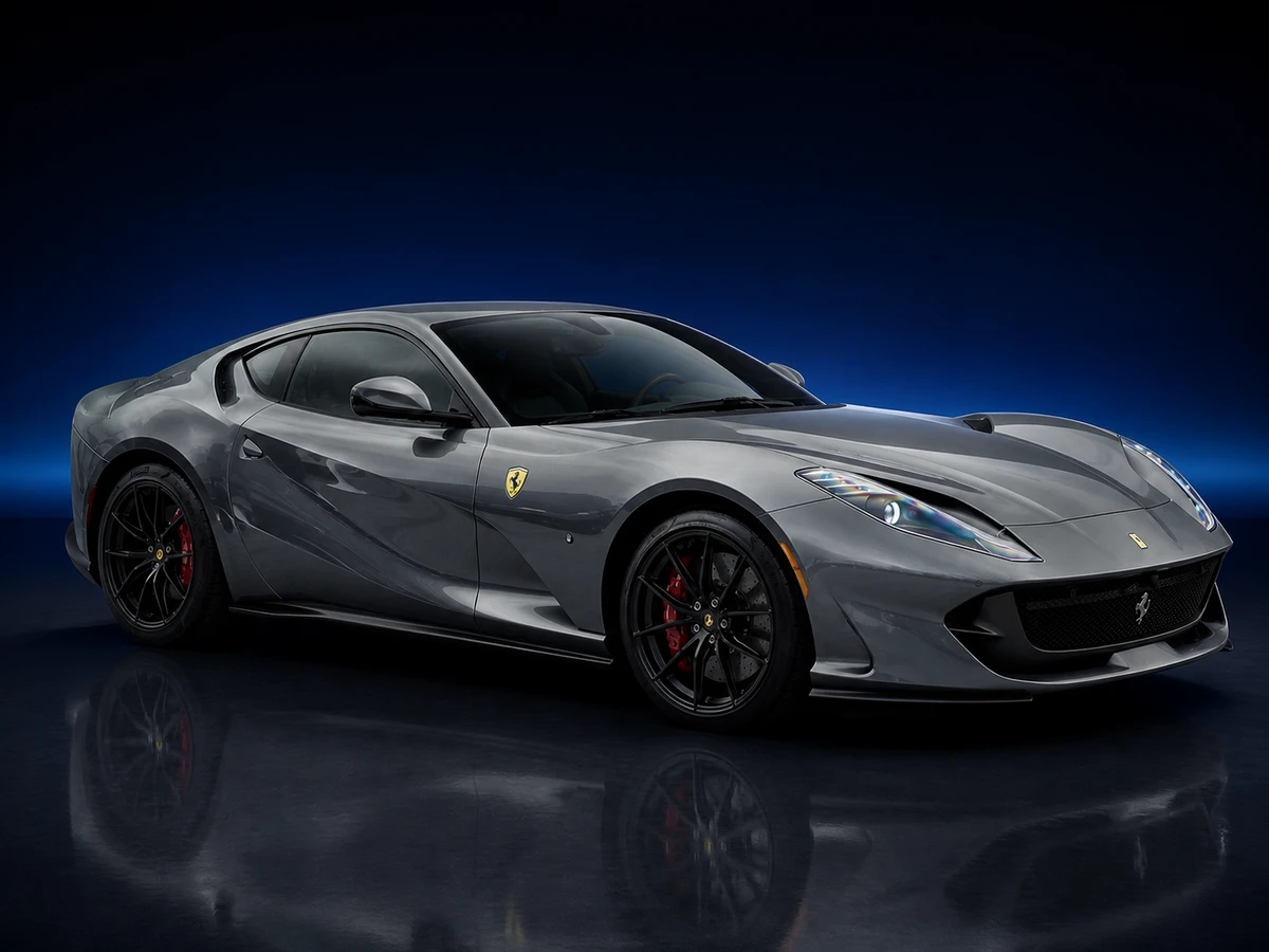 Grey Ferrari 812 Superfast coupé on a deep navy and cobalt studio background.