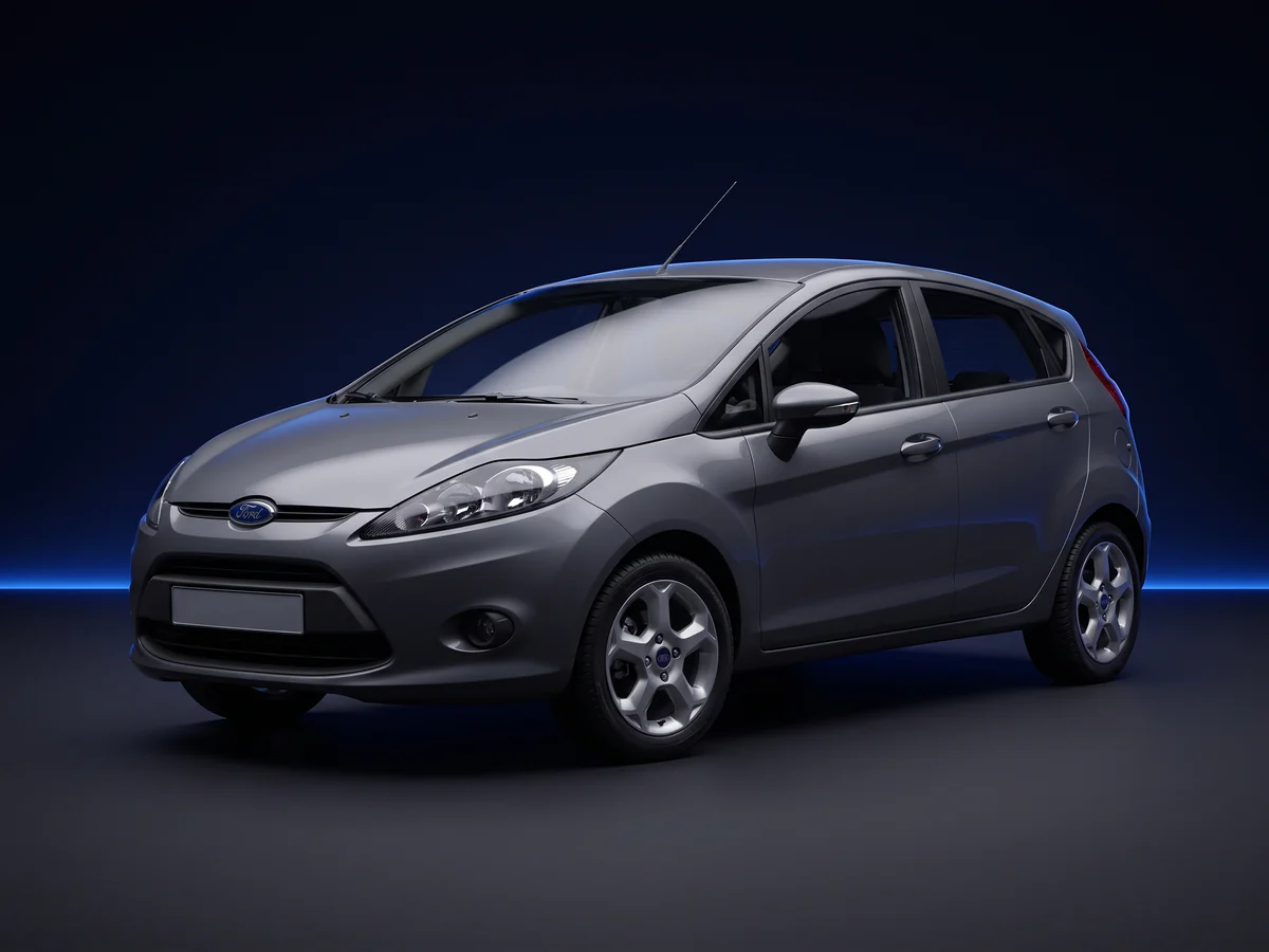 Grey Ford Fiesta Mk7 hatchback on a deep navy and cobalt studio background.