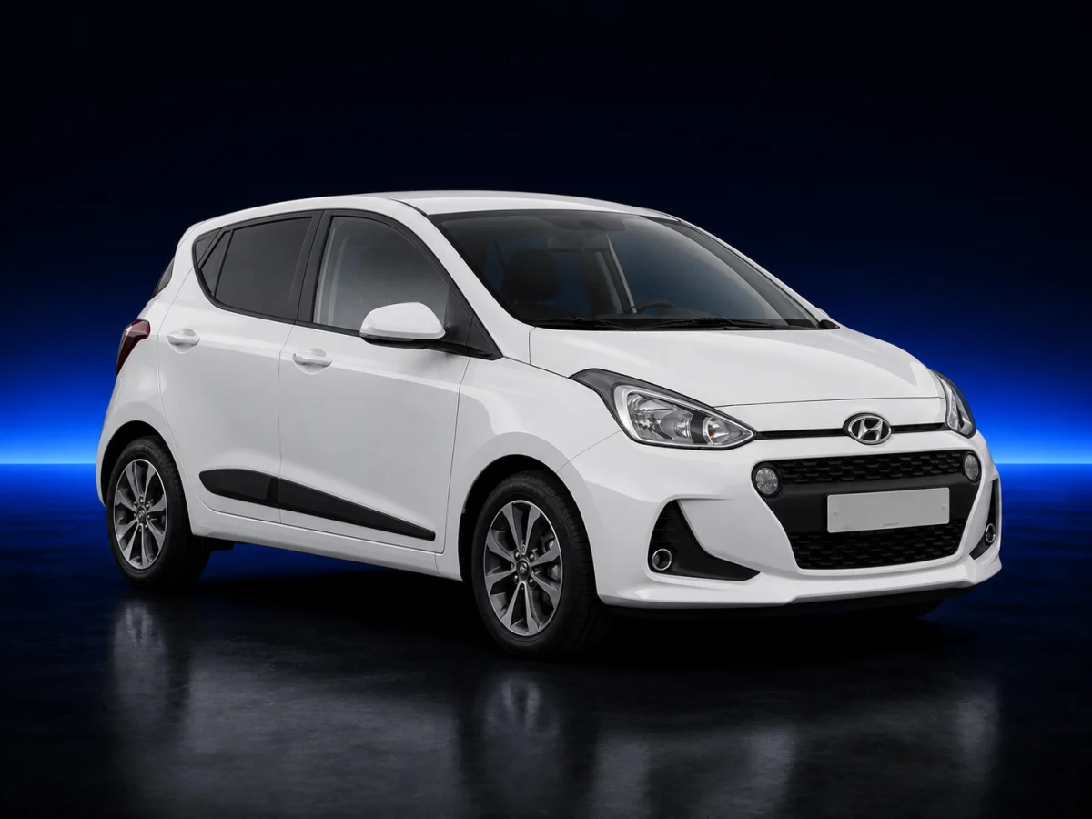 White Hyundai i10 II facelift on a deep navy and cobalt studio background.