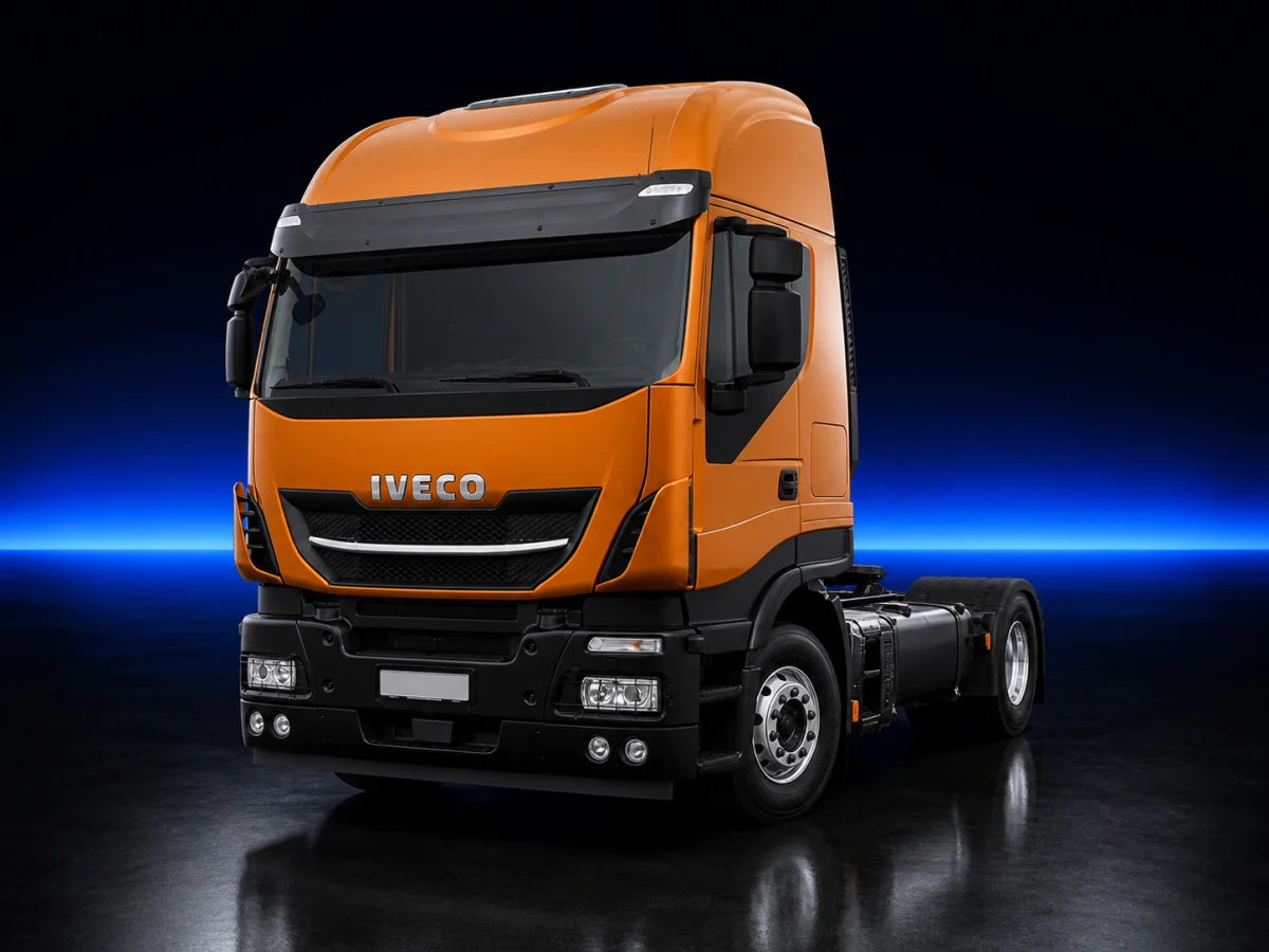 Orange Iveco Stralis II X-Way tractor unit on a deep navy and cobalt studio background.