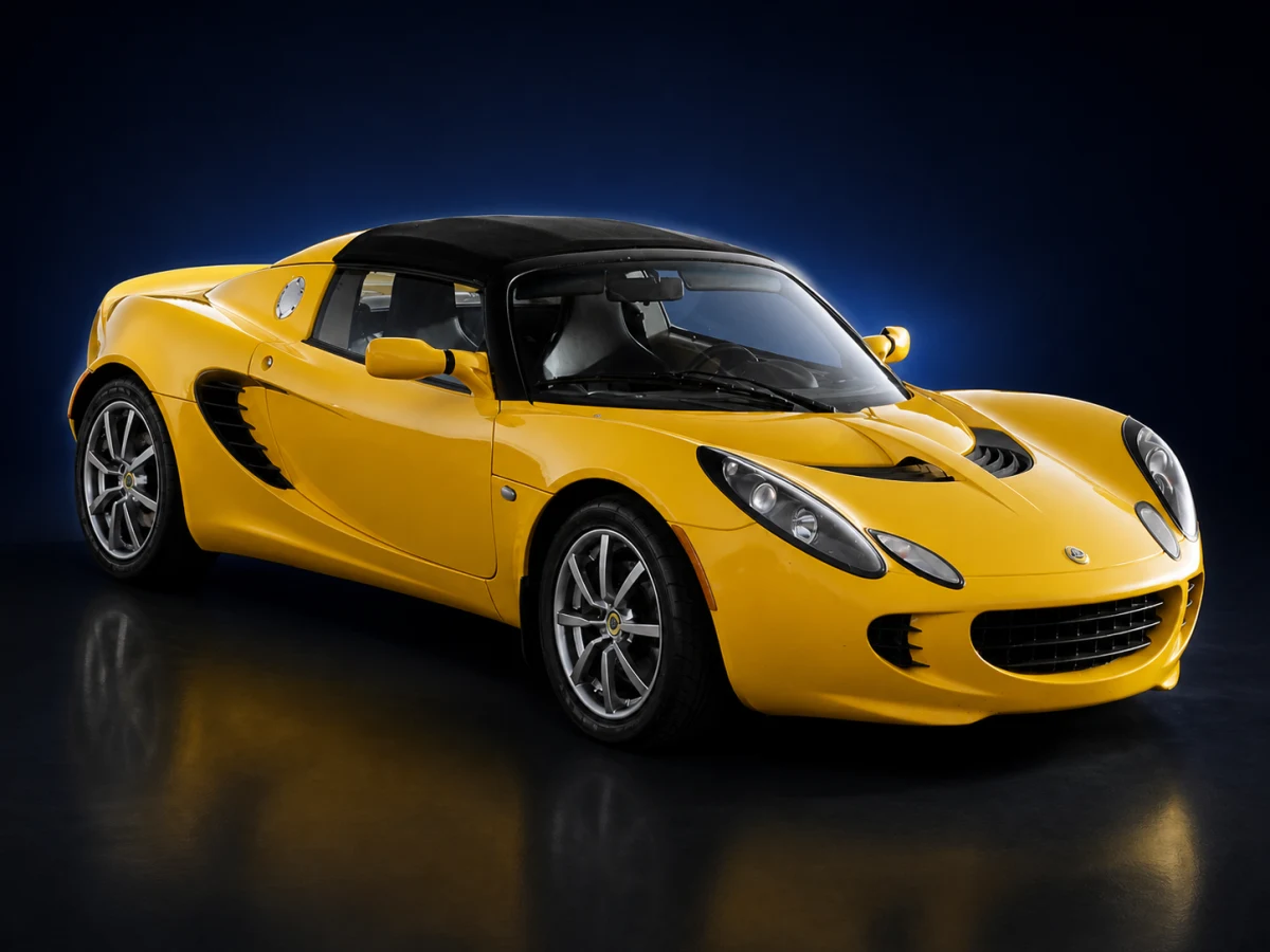 Yellow Lotus Elise Series 2 roadster on a deep navy and cobalt studio background.