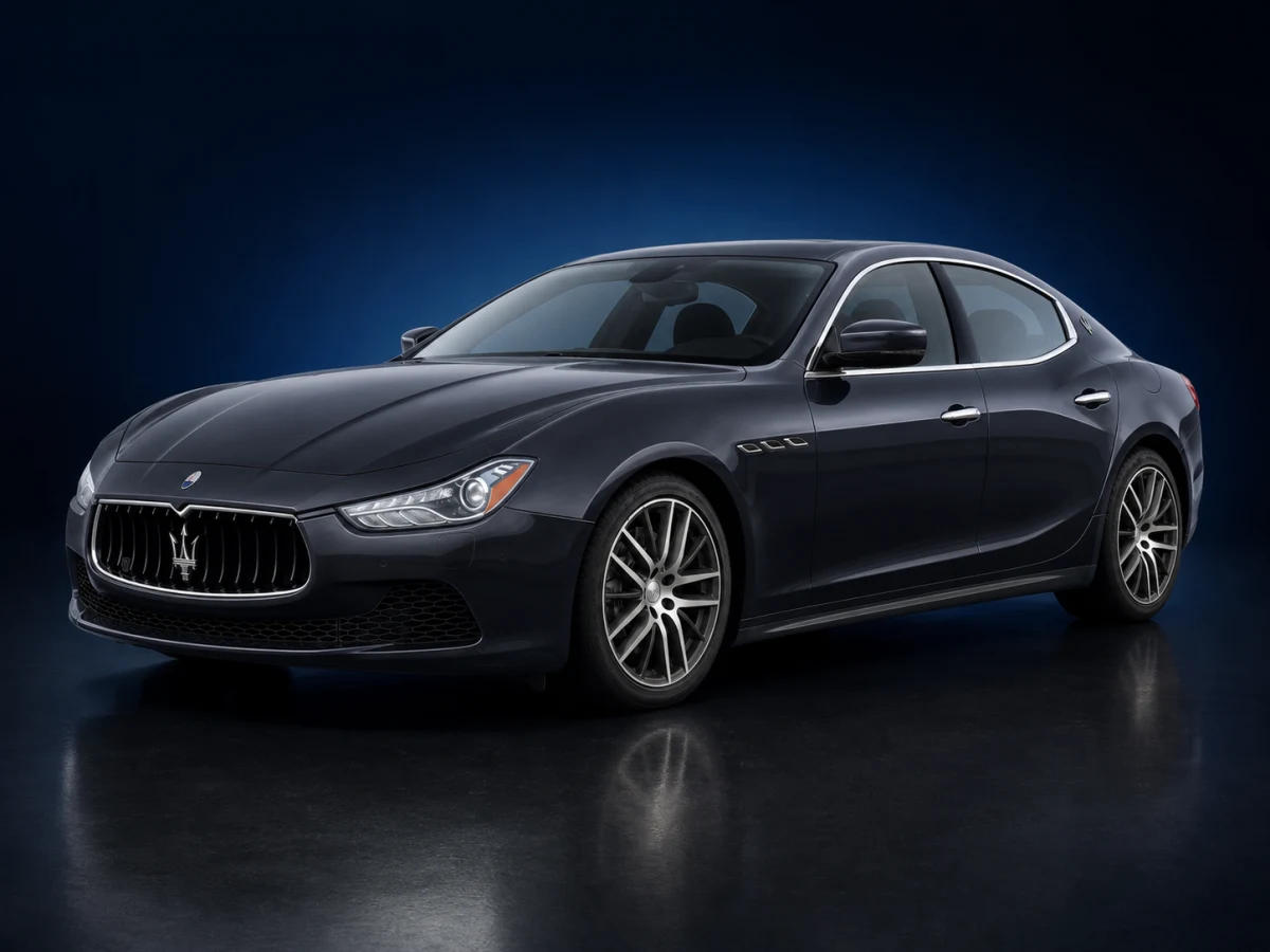 Dark graphite Maserati Ghibli M157 saloon on a deep navy and cobalt studio background.