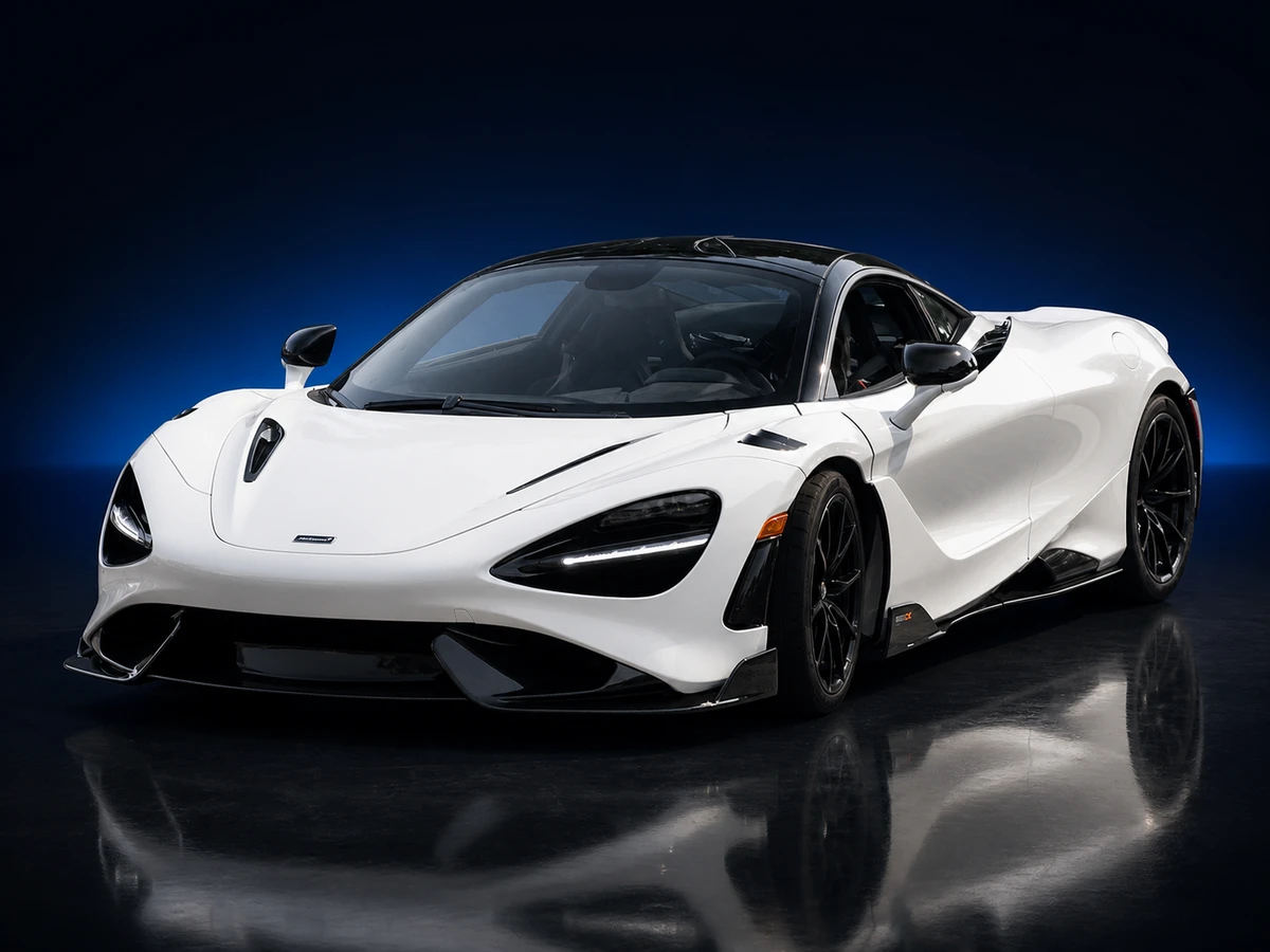 White McLaren 765LT coupé on a deep navy and cobalt studio background.