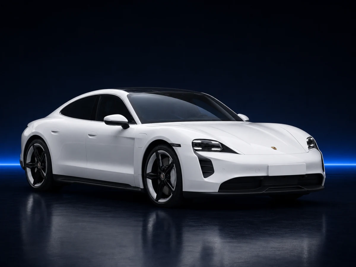 White Porsche Taycan J1 saloon on a deep navy and cobalt studio background.