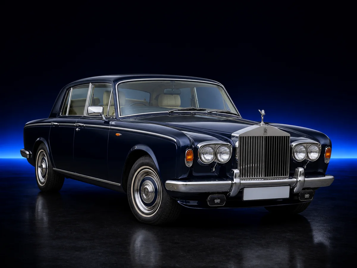Dark blue Rolls-Royce Silver Shadow on a deep navy and cobalt studio background.