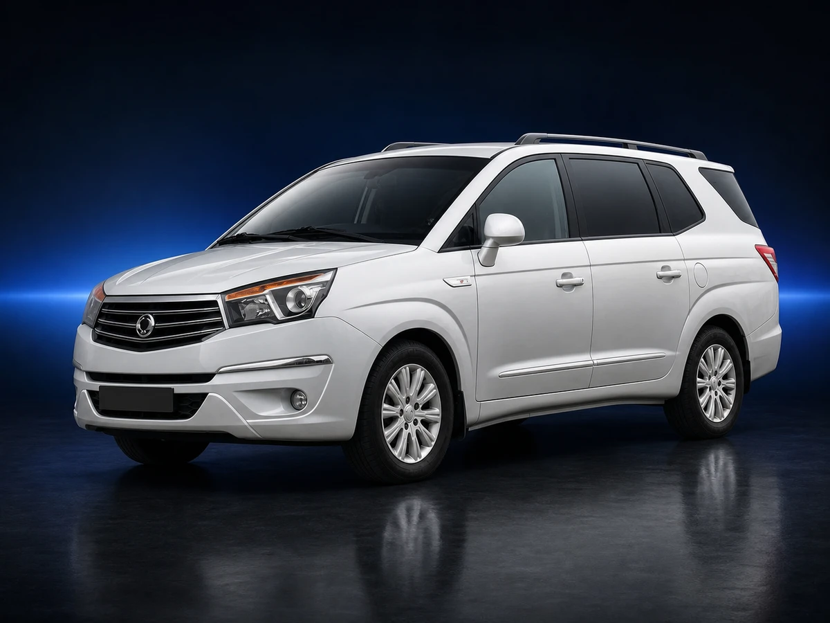 White SsangYong Turismo II UK-market MPV on a deep navy and cobalt studio background.