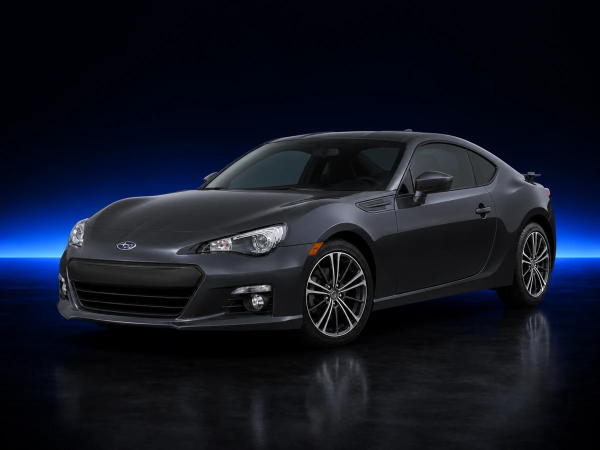 Dark grey Subaru BRZ first generation on a deep navy and cobalt studio background.
